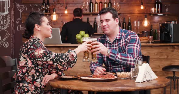 Caucasian Couple Eating Pizza and Drinking Beer