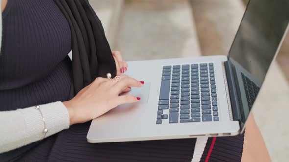 Close Up Shot Of A Woman Typing On A Laptop Outside In Slowmotion