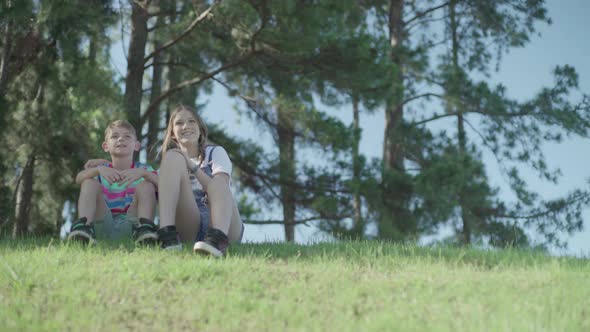 Children sitting together on hillside looking at view