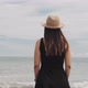 Woman In Hat And Black Dress Looking At The Sea - VideoHive Item for Sale