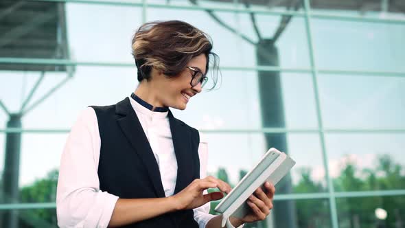 Young Beautiful Businesswoman Looking at Tablet Smiling Business Centre Background