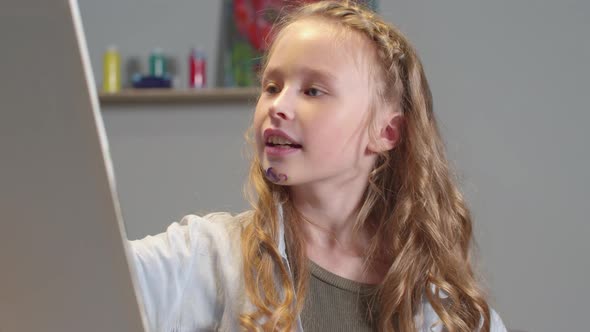 Smiling Girl Draws a Picture in the Studio