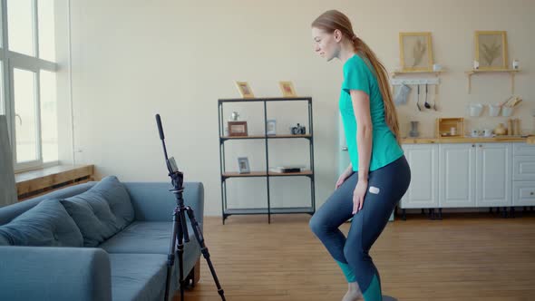 Athletic Woman Conducts Training Online. Concept Exercise at Home Via Smartphone