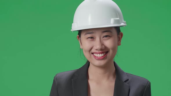 Close Up Of Asian Female Engineer With Safety Helmet Smiling In The Green Screen Studio