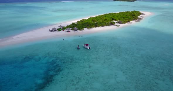 Wide birds eye copy space shot of a white sandy paradise beach and aqua blue ocean background in 4K