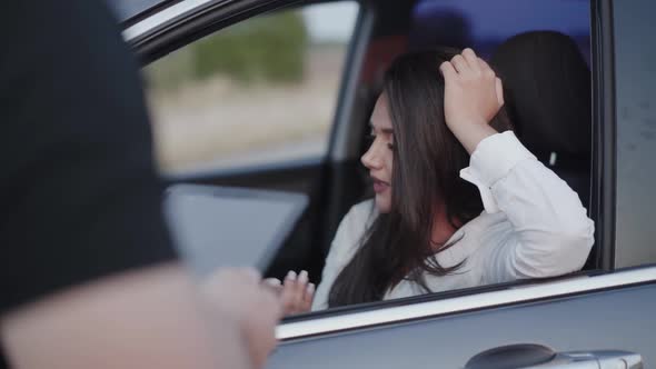 Attractive Brunette in Car Talking with Officer with Gadget and Rejoicing