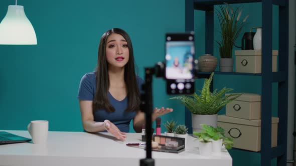 Asian Woman Filming Makeup Tutorial with Smartphone Camera