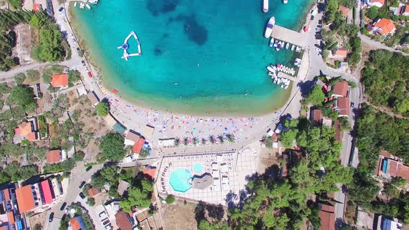 Flying above touristic resort at turquoise bay of Solta island