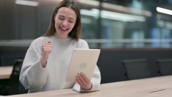 Successful Woman Celebrating on Tablet at Work