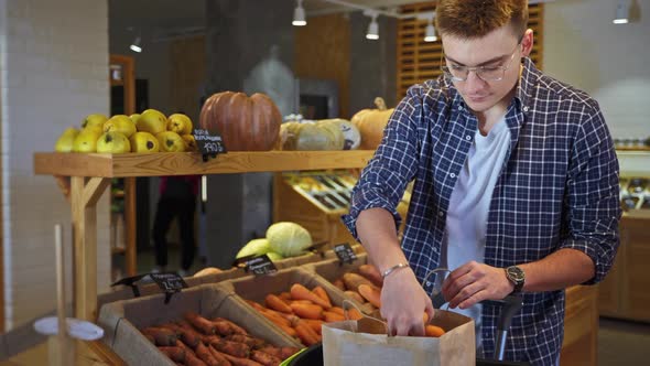 Customer Buying Carrots in Greengrocery