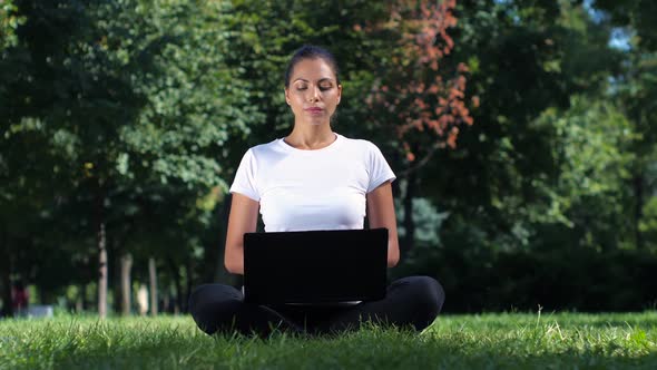 Female Student Sitting in the Park Using Laptop