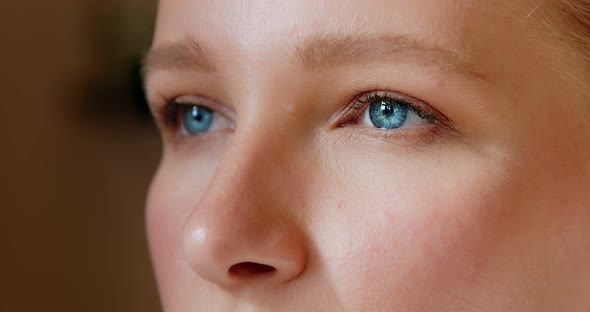 Close up of blonde woman face opening her beautiful blue eyes looking feel happy the morning sun