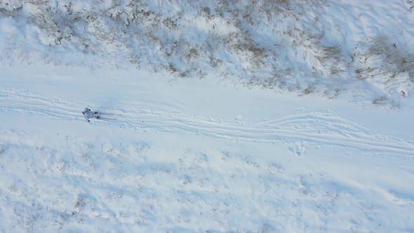 Skier in Winter Camouflage and Arms Walking Along the Track