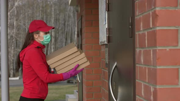Girl-courier with pizza comes to door. Coronovirus pandemic