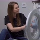 Woman Opens Door of Washing Machine Puts in Dirty Clothes and Takes Out Clothes - VideoHive Item for Sale