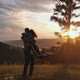 Couple of Young People in Love at Sunset. A Woman in the Arms of Her Man on Top of a Mountain - VideoHive Item for Sale