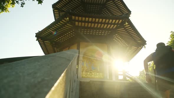 A man runs up the stairs in the historic London Battersea Park with the sun bursting around the corn