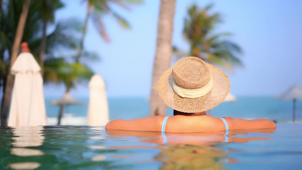 Young asian woman enjoy around outdoor swimming pool for leisure