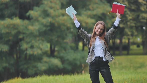 A Cheerful Student with Books in the Park in the Summer