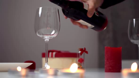 A Man's Hand Pours Wine. Wine Is Poured Into A Glass From A Bottle