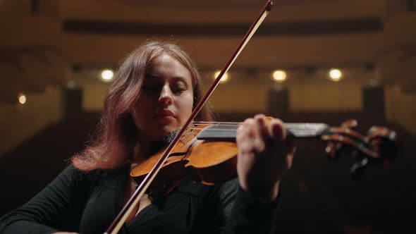 Female Student Musician is Playing Violin on Scene in Modern Opera House Woman Violinist