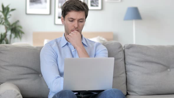 Man Thinking and Working on Laptop while Sitting on Couch