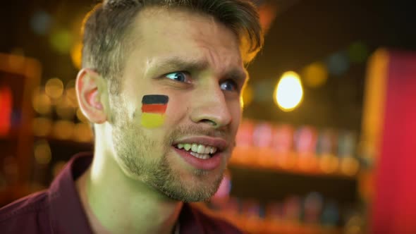 Disappointed Male Fan With German Flag Painted on Cheek Waving Hand, Failure