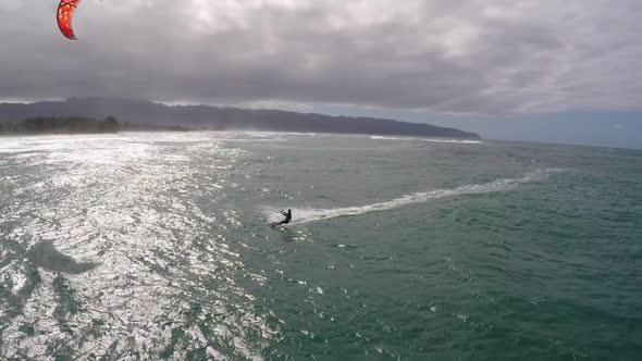 Aerial view of a man kitesurfing in Hawaii.