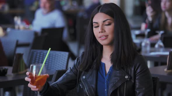 pretty young Asian woman  at the restaurant,drinking cocktail