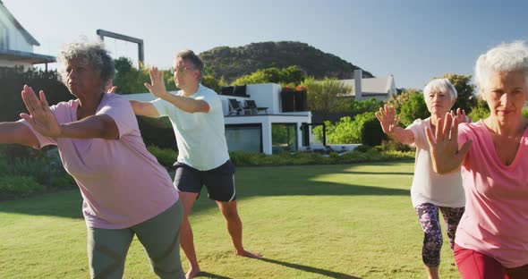 Senior diverse people exercising in garden on sunny day at retirement home