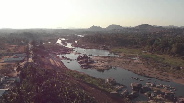 Tungabhadra River flow cascading alongside the rocky landscape Hampi town's edge in Karnataka, India