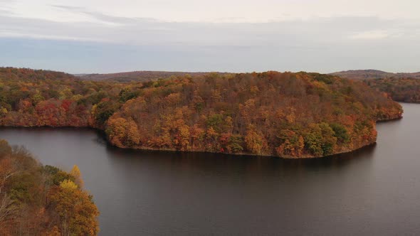 aerial truck shot, left over the reservoir, as the drone camera focuses on the orange colored tree t