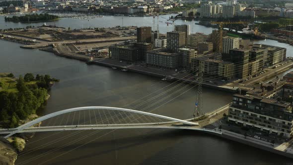 Aerial, tilt up, drone shot away from the Isoisansilta bridge, revealing the Sompasaari island and d