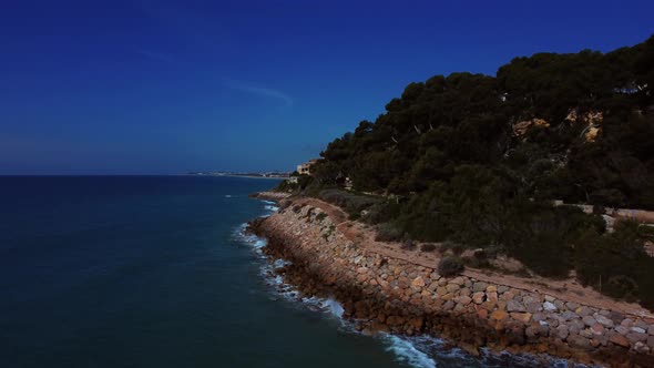 Paseo_RodaDeBara_2022_4K. Vista aérea del lateral de la costa junto a un paseo de la costa catalana.
