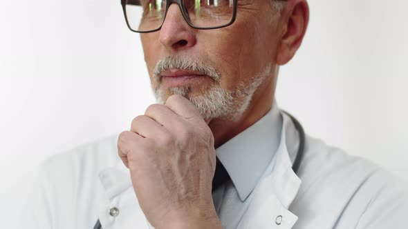 Face of an Elderly Serious Male Doctor with a Beautiful Gray Beard in Closeup