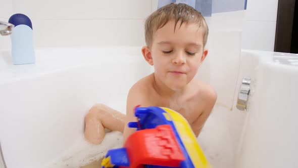 Cute Little Boy Taking Bath at Home and Playing Iwth Colorful Toy Ship or Boat