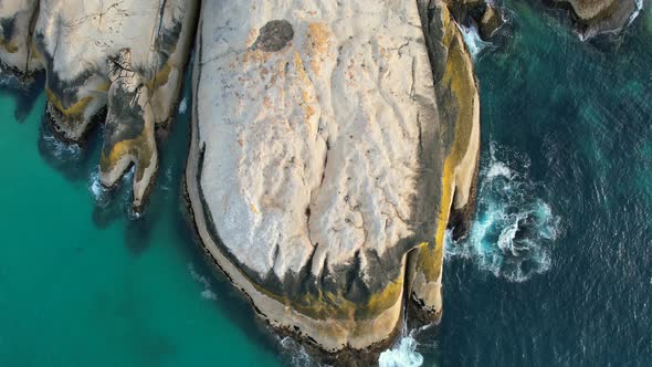 top down view zoom out of large boulders at Llandudno Beach Cape Town, aerial