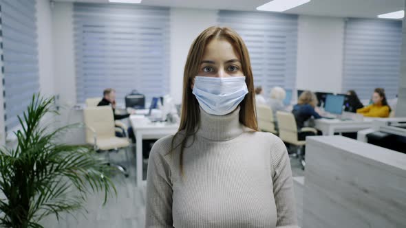 Portrait of a Woman in Glasses and a Protective Mask Looking Into the Camera Office Worker