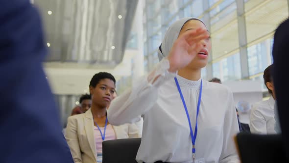 Mixed-race businesswoman raising hand in the business seminar 4k