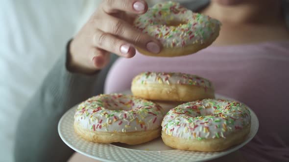 Video of pregnant woman eating tasty donuts in bed, Shot with RED helium camera in 8K 