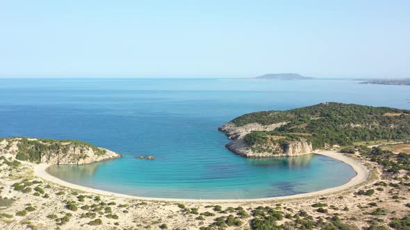 Aerial drone video of semicircular sandy beach and lagoon of Voidokilia