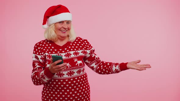 Grandmother Santa Christmas Sweater with Mobile Phone Showing Pointing Empty Place Advertising Area