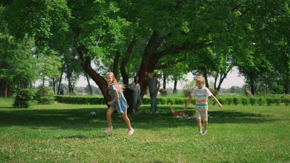 Active Girl Running Around Boy on Green Grass