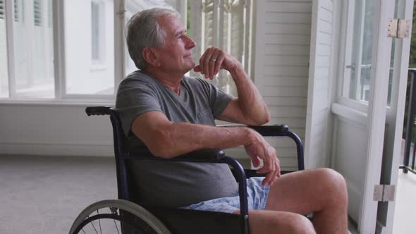 Senior Caucasian man on a wheelchair looking at the window