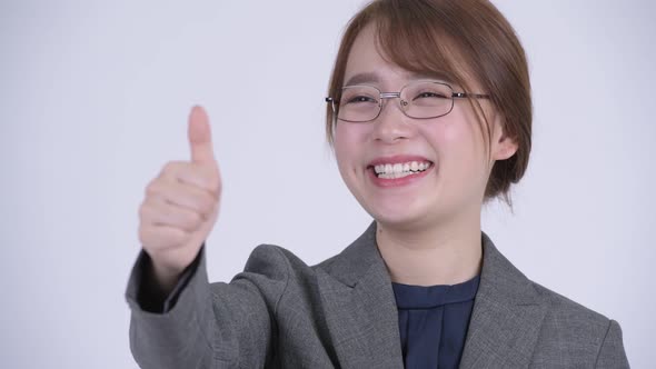 Face of Young Beautiful Asian Businesswoman Giving Thumbs Up