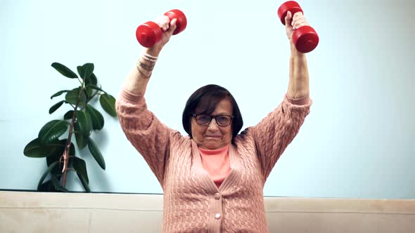 Mature Woman Training With Dumbbells On Home. Senior Woman Workout Weight Lifting.Active Grandmother