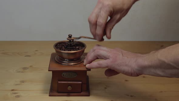 Man Grinds Coffee Beans In A Manual Vintage Coffee Grinder