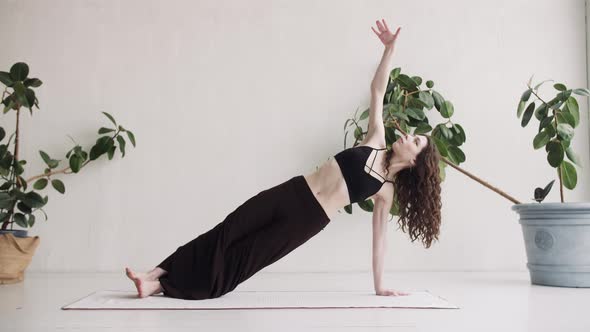 The Girl Performs One of the Yoga Exercises. Young Girl with Long Curly Hair Does Yoga.