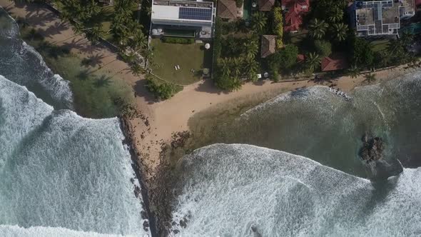 White Ocean Waves Roll on Coastline with Tourist Complex