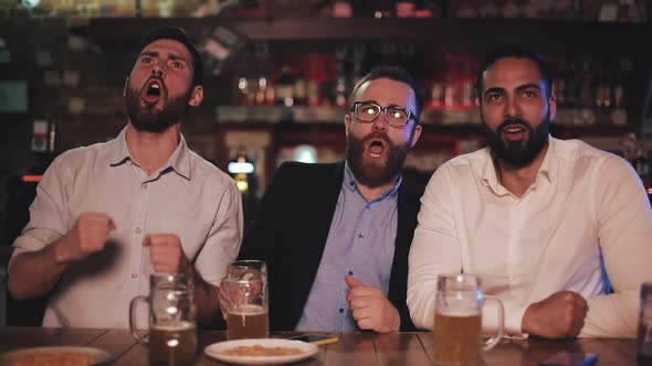 Three Old Friends Drinking Beer, Cheering Together in a Pub. Football Fans, Friendship, Sports